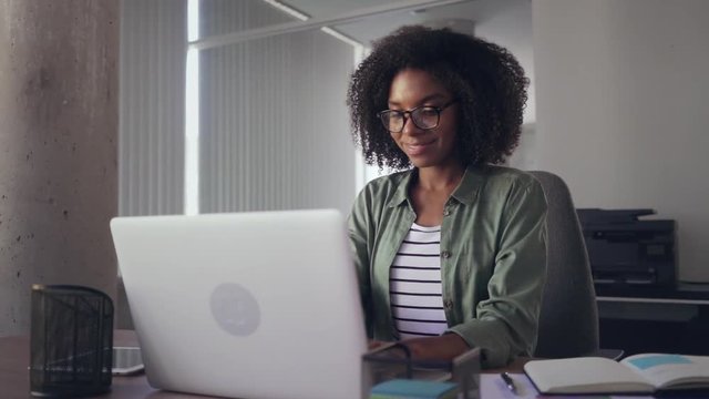 Creative young businesswoman using laptop at her office desk