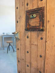 A partly opened old prison cell door, allowing a view in an old fashioned jail.