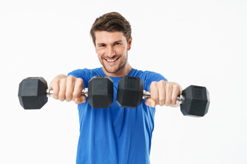 Fototapeta na wymiar Full length photo of happy sportsman in shorts and t-shirt lifting weights while doing workout