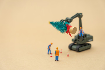 Miniature people Construction worker standing on Christmas tree Celebrate Christmas on December 25 every year. using as background xmas concept with copy spaces for you