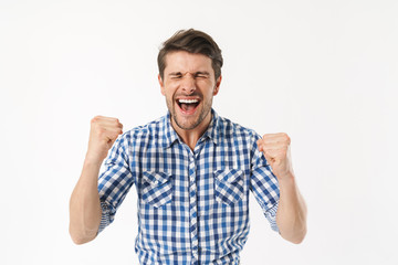 Photo of excited man in plaid shirt screaming and rejoicing with fists clenched