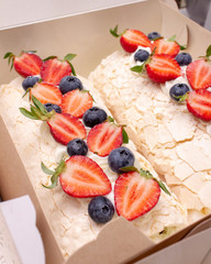 Meringue roll decorated with berries. 