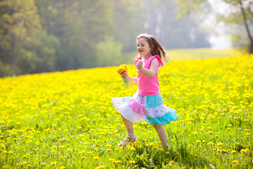 Kids play. Child in dandelion field. Summer flower
