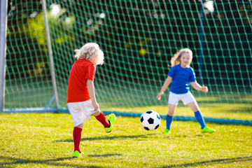 Kids play football. Child at soccer field.