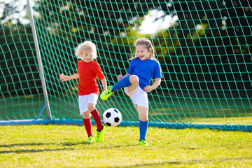 Kids play football. Child at soccer field.