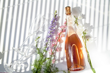 a bottle of pink champagne, cold rose wine, glasses, flowers, ice