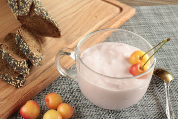 still life with fresh sweet cherry and cherry yogurt on a table