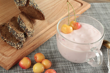 still life with fresh sweet cherry and cherry yogurt on a table