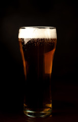 beer glass of fresh, tasty beer on a dark background