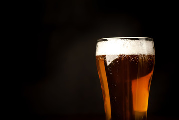 beer glass of fresh, tasty beer on a dark background