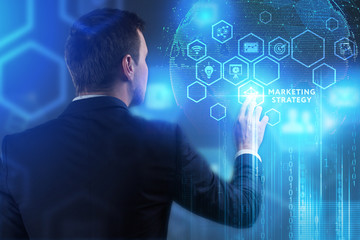 The concept of business, technology, the Internet and the network. A young entrepreneur working on a virtual screen of the future and sees the inscription: marketing strategy