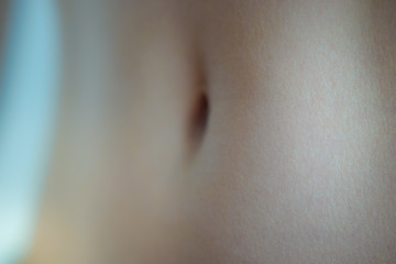 Fototapeta premium Female belly white skin with navel closeup