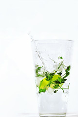 Glass of water with lemon and ice on white background