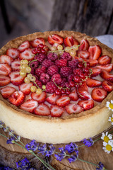 tart with fresh strawberries, raspberries and currants in a rustic style