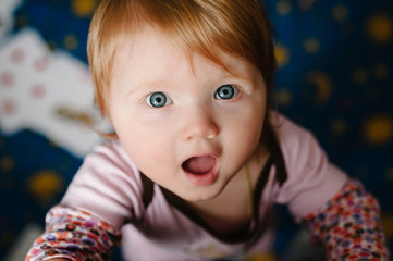 A beautiful little baby girl looking into the camera speaks and congratulates mother on the day of mother and father's day father. flat lay. top view.