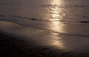 Olas del mar en la playa al anochecer