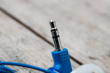 blue headphones jack on a wooden board, close-up