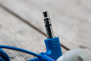blue headphones jack on a wooden board, close-up