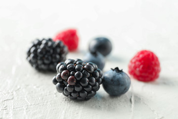 Berries on white cement background, closeup and space for text