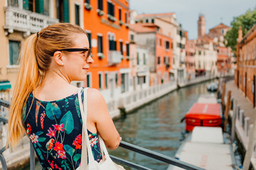 Fototapeta na wymiar Young woman standing on the bridge in Venice, Italy enjoying the view