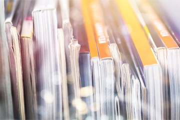 Closeup photo of row of old books and brochures with colorful covers