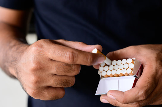 Close Up Of Male Hand Take A Pack Of Cigarette. Stop Smoking Concept