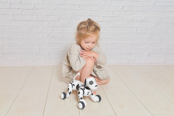 the baby girl playing takes care of dog robot