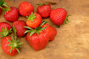 freshly picked strawberries on a rustic wooden table top