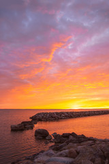 Fototapeta na wymiar Portrait image on beautiful summer sunrise by the sea and colorfull cloudy sky.