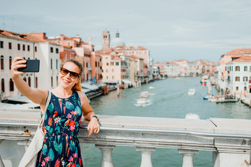 Fototapeta na wymiar Young woman using smartphone in Venice, Italy