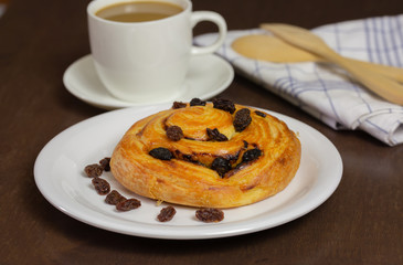 Close up custard raisin danish bread and coffee cup