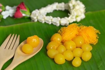 Golden tasty thai dessert on green banana leaf background