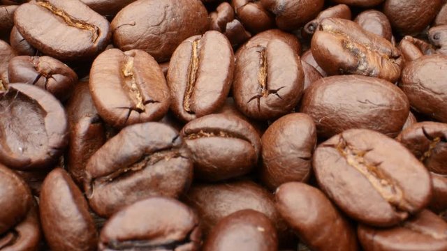 Close-up, smooth moving roasted coffee beans