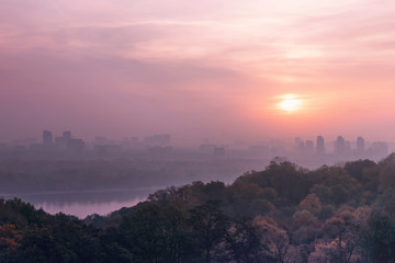 Pink Early morning, fog in the city. Pink dawn over the river in the metropolis. Cityscape Kiev, Ukraine, Europe.