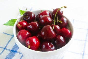 Fresh cherry on plate on wooden white background. fresh ripe cherries. sweet cherries.
