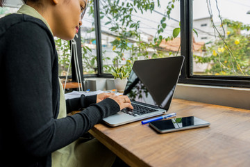 Asian woman working on laptop at green office space