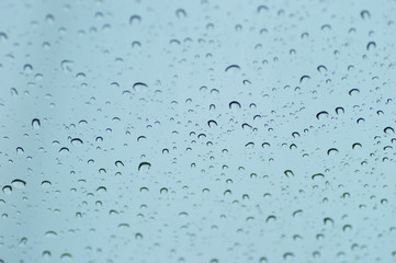 Water drops of rain on blue glass background