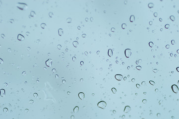 Water drops of rain on blue glass background