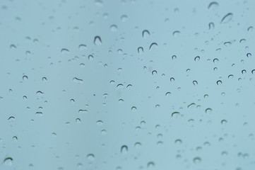 Water drops of rain on blue glass background