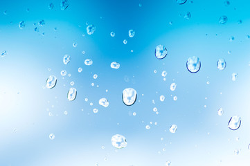 Water drops of rain on blue glass background