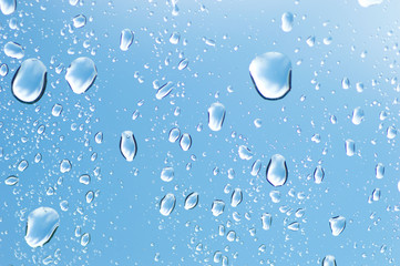 Water drops of rain on blue glass background