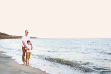 Father and son stay on the sea coast. Family vacation. Friendship