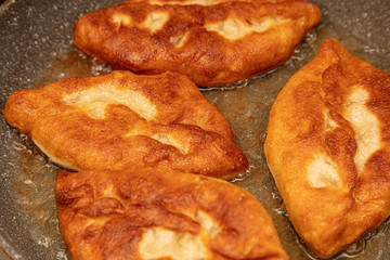 Patties are fried in oil in a pan