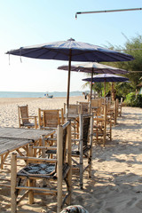 Bamboo table, chair and umbrella on the beach.