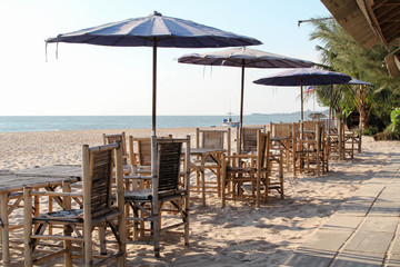 Bamboo table, chair and umbrella on the beach.