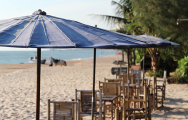 Bamboo table, chair and umbrella on the beach.