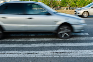 Car at high speed passes through a pedestrian Zebra.