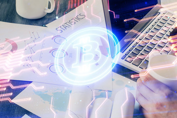 Crypto currency theme hologram with businessman working on computer on background. Concept of blockchain. Double exposure.