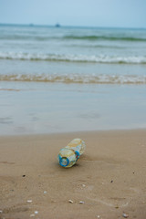 Plastic bottle found half left on the beach in the morning. A starting point of the environment problem.