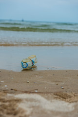 Obraz premium Plastic bottle found half left on the beach in the morning. A starting point of the environment problem.